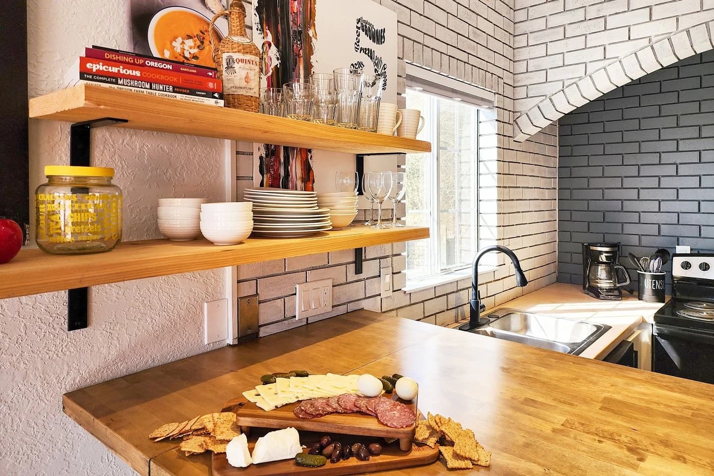 Butcher-block kitchen with charcuterie, wood shelves, and black faucet in Newport
